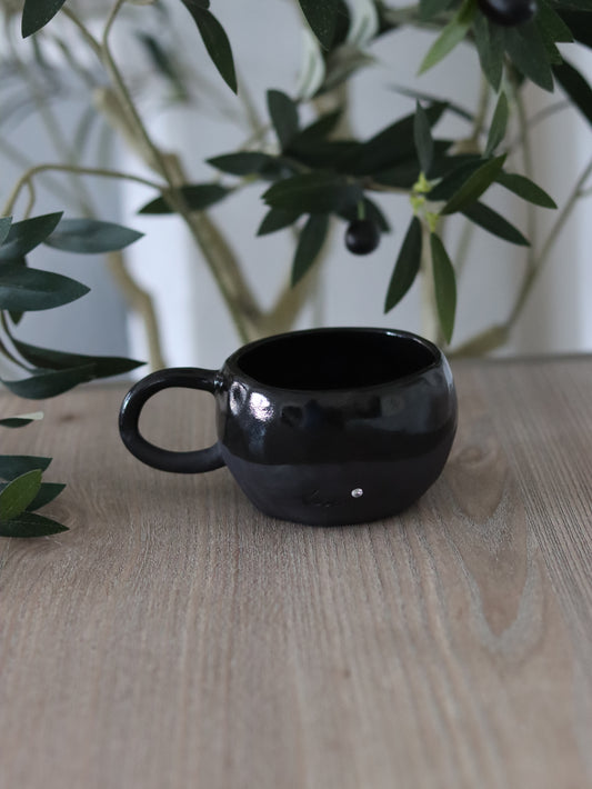 Handgetöpferte Tasse aus schwarzem Steinzeug mit einem Zirkonia Stein