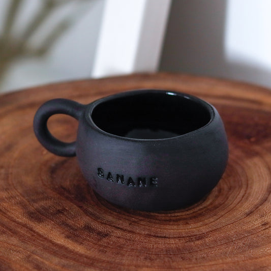 Motto Tasse schwarz „SANANE“